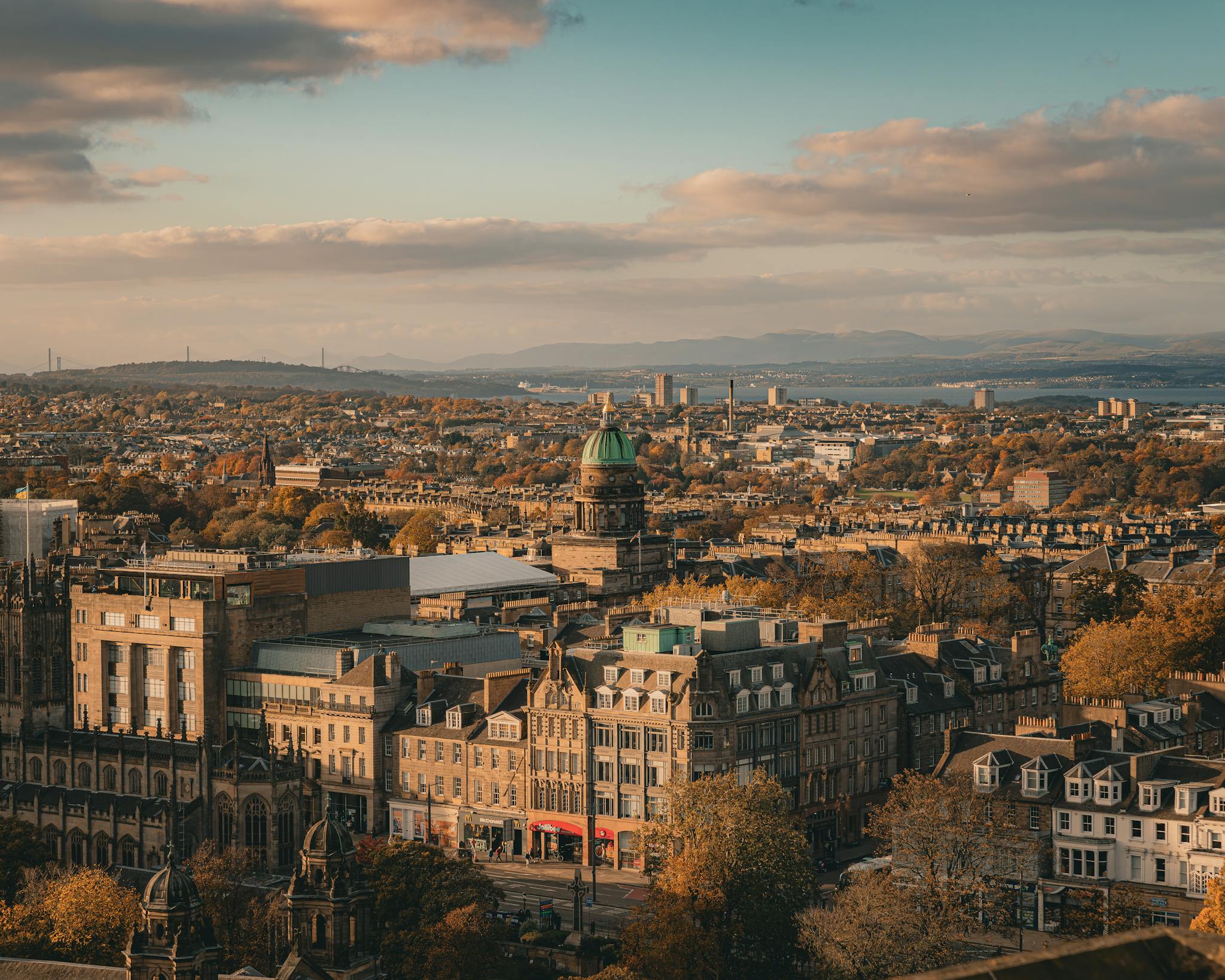Stunning aerial view of Edinburgh, Scotland, showcasing historic architecture and rooftops at dusk.