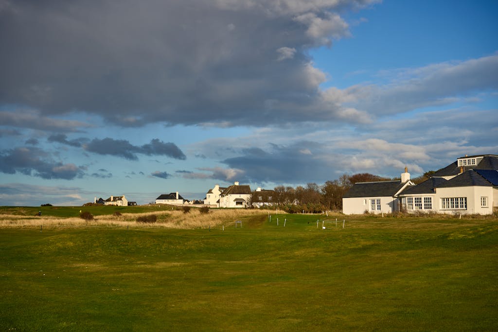 Beautiful spring landscape of Gosford Bay's charming cottages against a dramatic sky in East Lothian, Scotland.